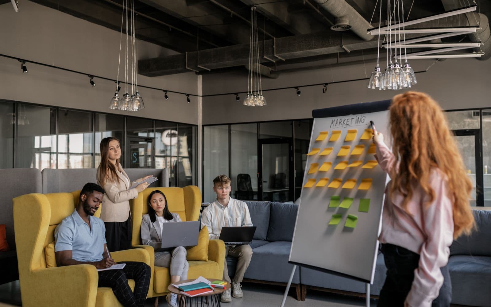 Marketing team planning a campaign at a whiteboard with sticky notes